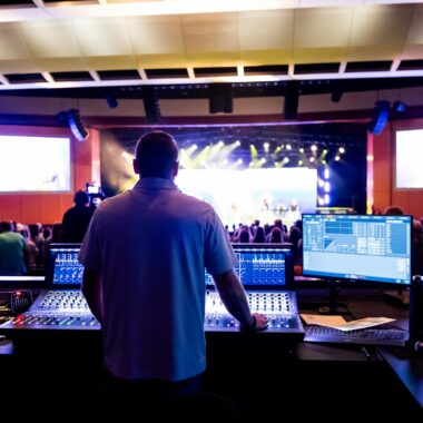 Sound engineer managing control desk during a live music event in an indoor venue.